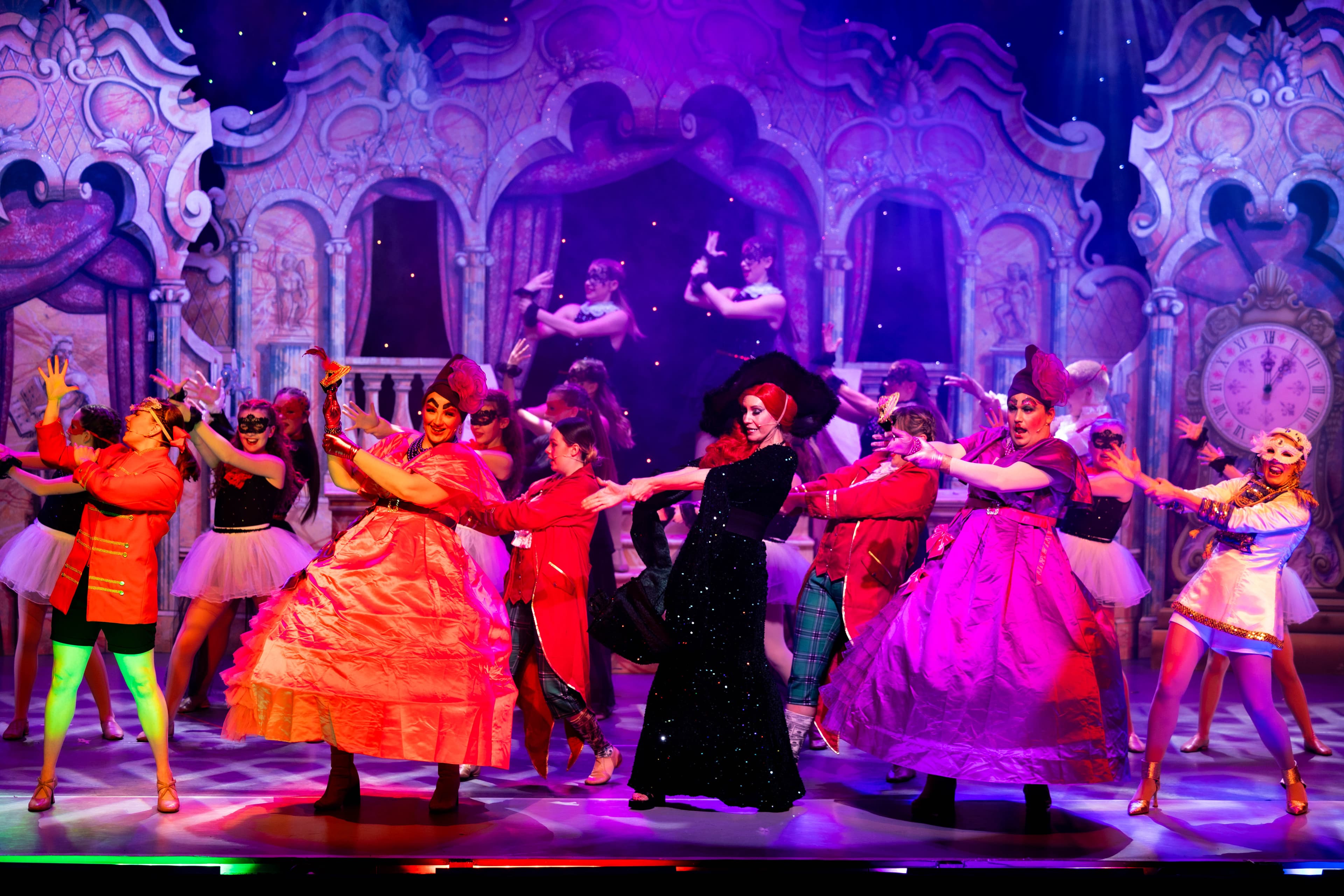 The Wicked Stepmother dances with Zoflora and Lenore in the masquerade ball. The stage is lit in purple, red, and blue.