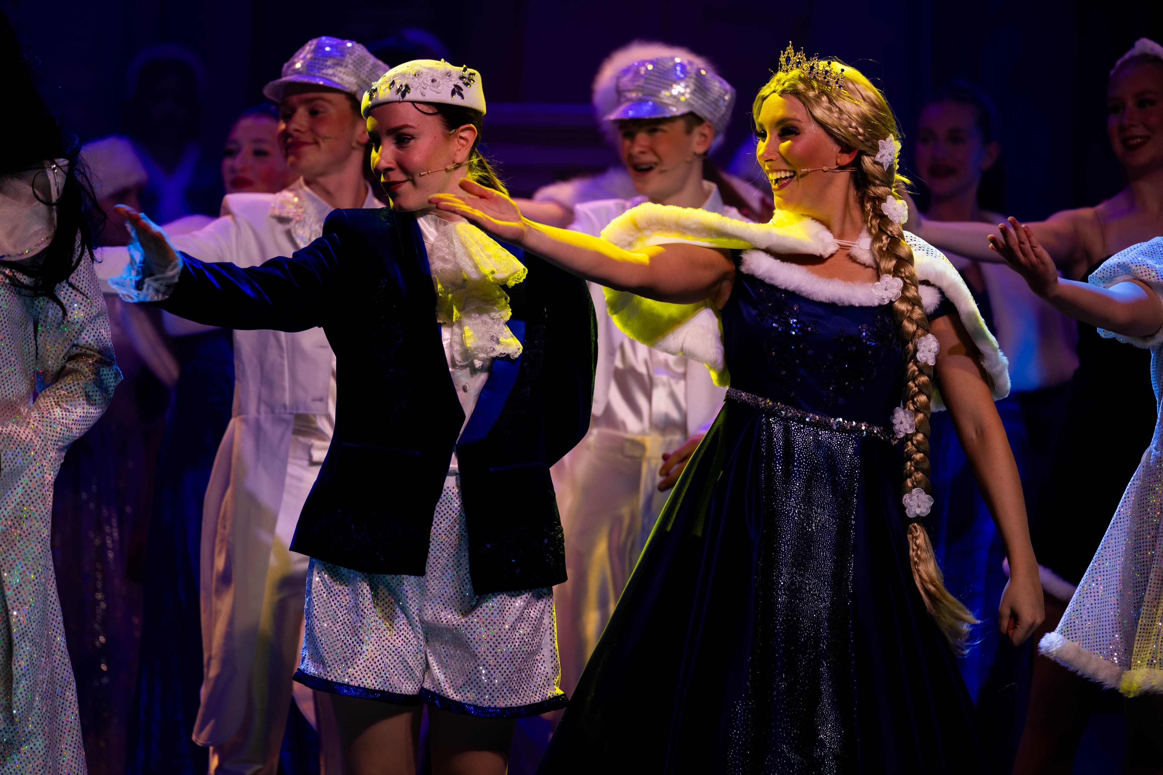 Jack and Rapunzel are pictured gesturing towards the band during the finale. They are in elegant blue and white finale outfits, and lit from above in yellow.
